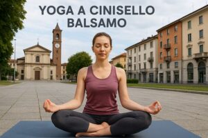 Una donna pratica yoga all'aperto in posizione di meditazione seduta e a occhi chiusi, con edifici e una chiesa sullo sfondo. Il testo recita "Yoga a Cinisello Balsamo.